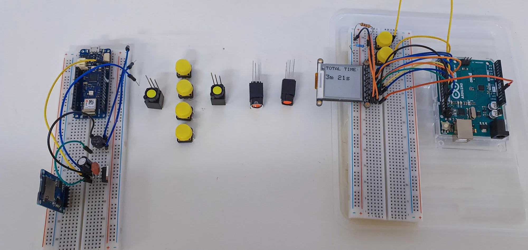 The internal electronics laid out, showing the Arduino board, breadboard, buttons, and wiring